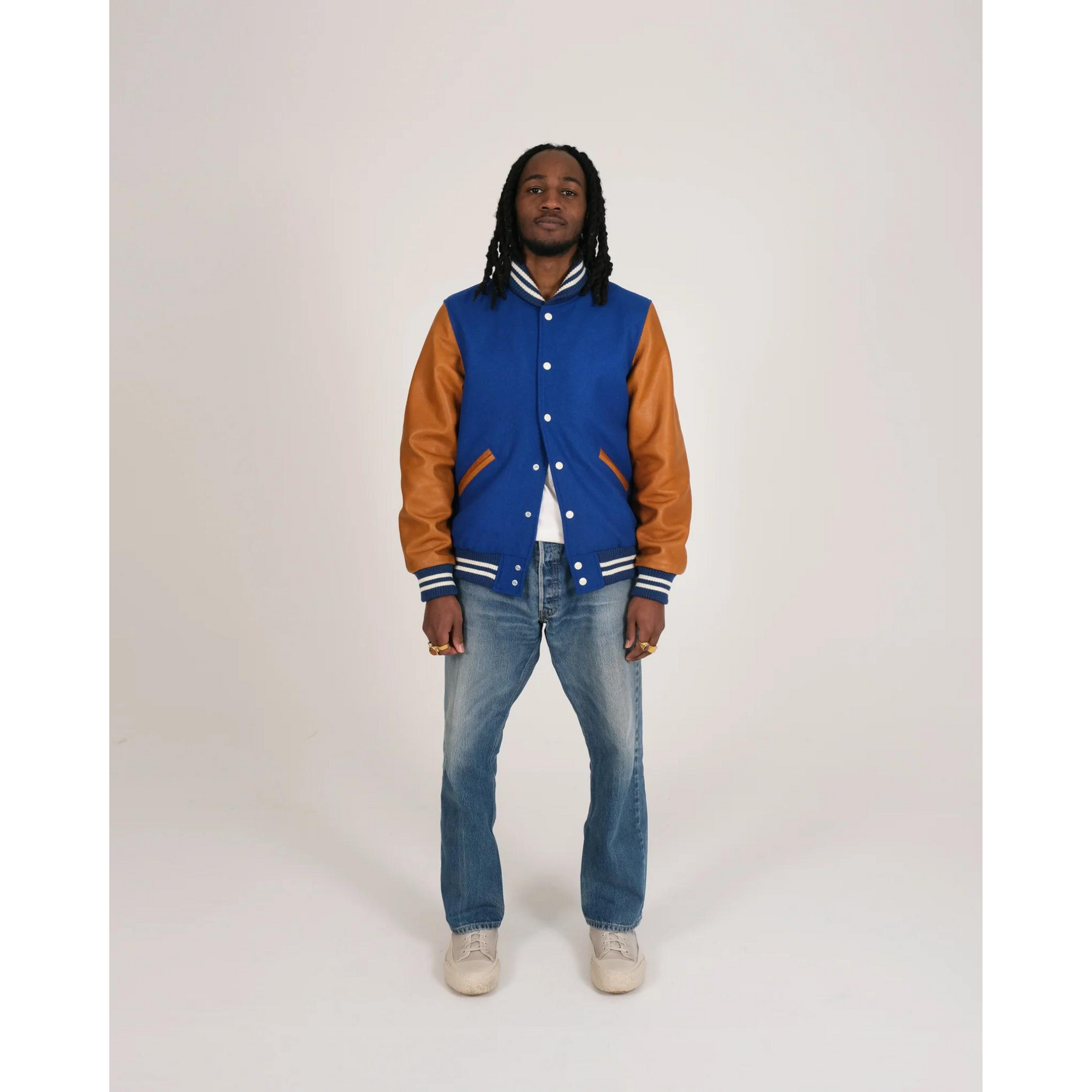 Model wearing blue varsity jacket front view