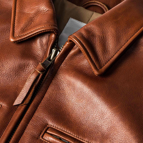 Zipper detail on a brown leather rider jacket.