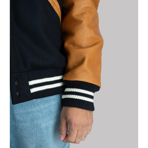 Close-up of the cuff and sleeve details on the Black Varsity Jacket with Brown Leather Sleeves – showing the premium leather texture and striped ribbed cuffs.