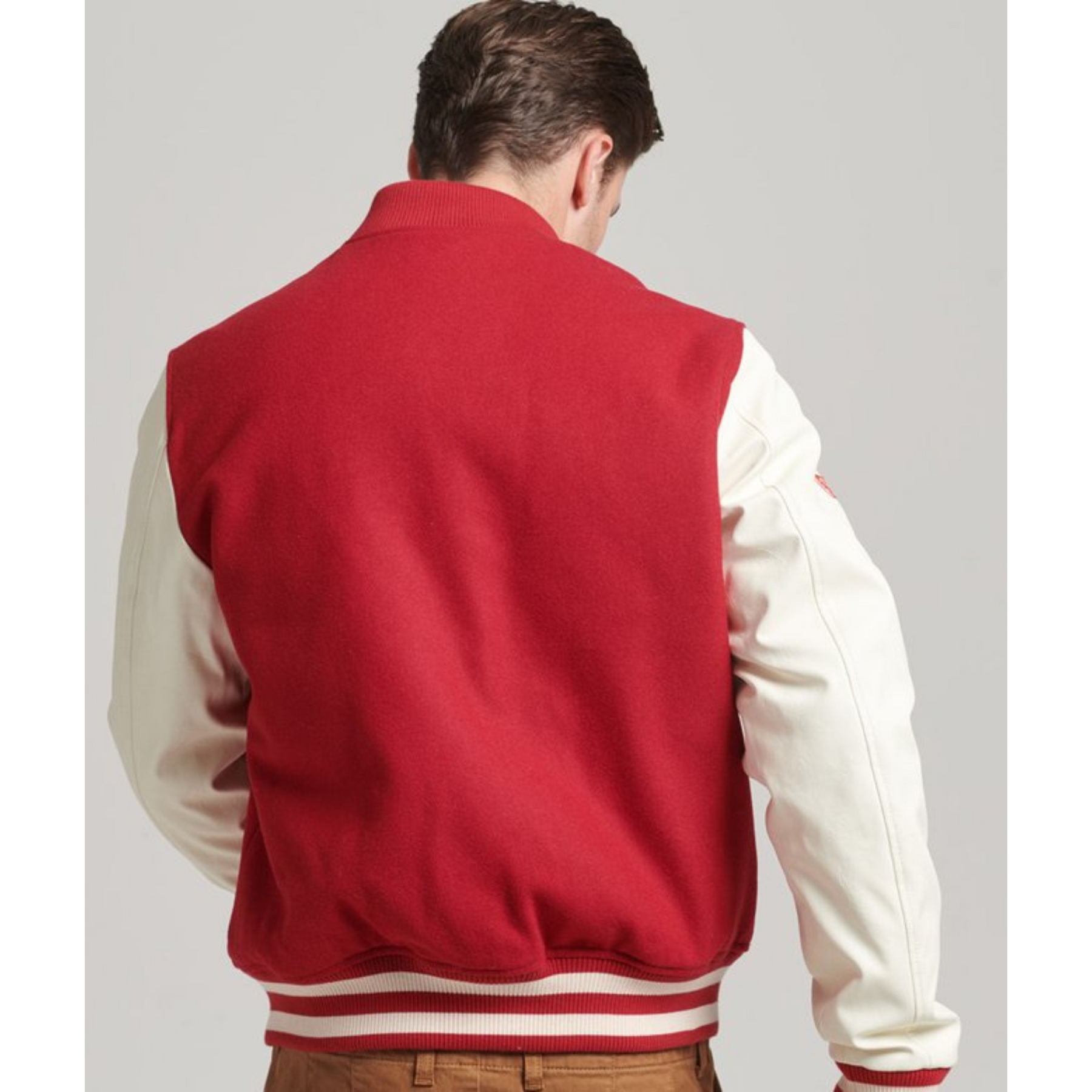 Back view of a men's red varsity jacket with white sleeves, Alpha Apparel.