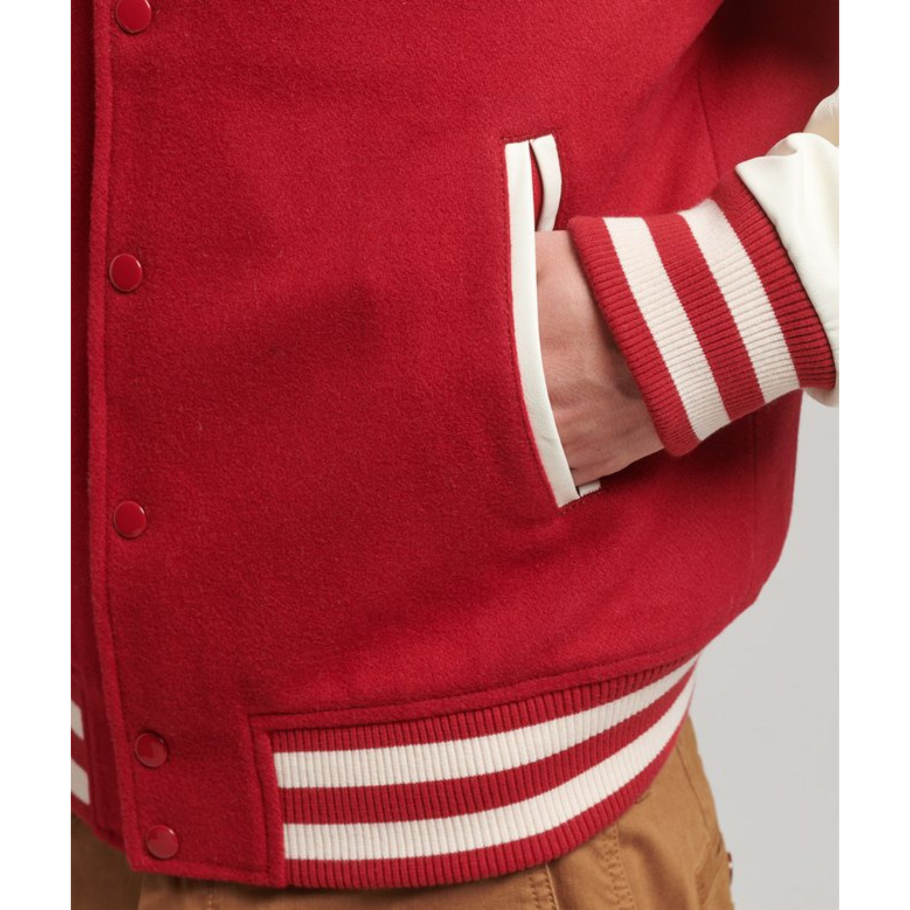 Close-up of the pocket detail on a men's red varsity jacket, Alpha Apparel.