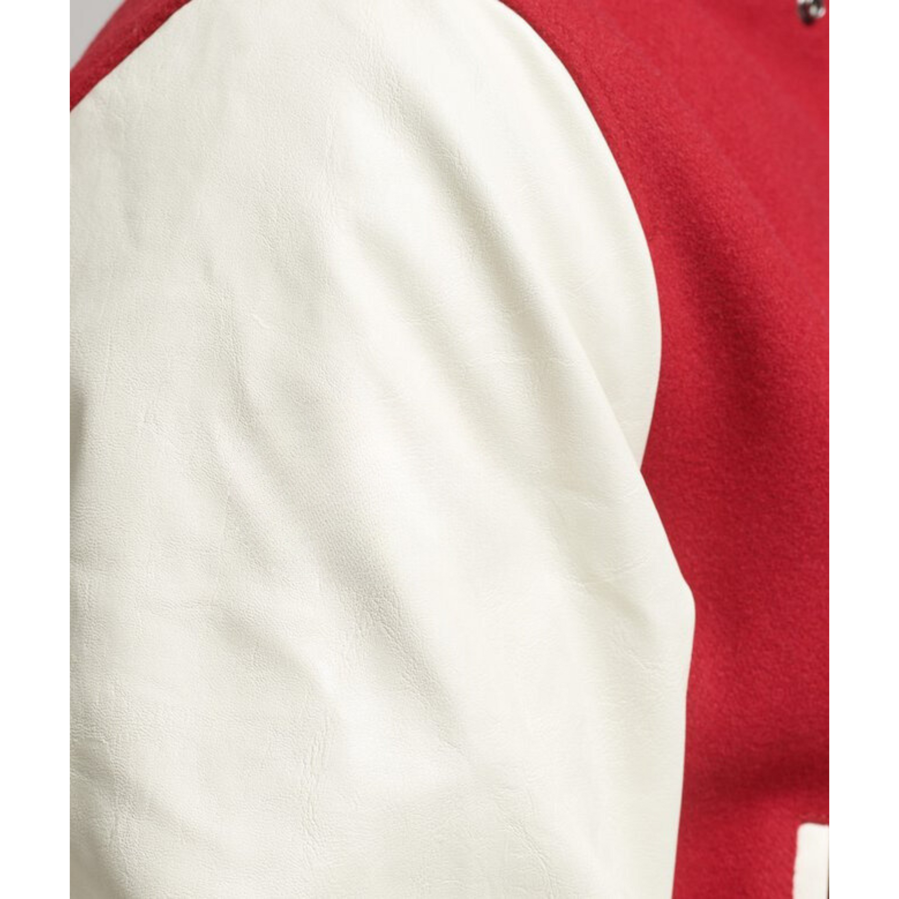 Close-up of the white sleeve on a men's red varsity jacket, Alpha Apparel.