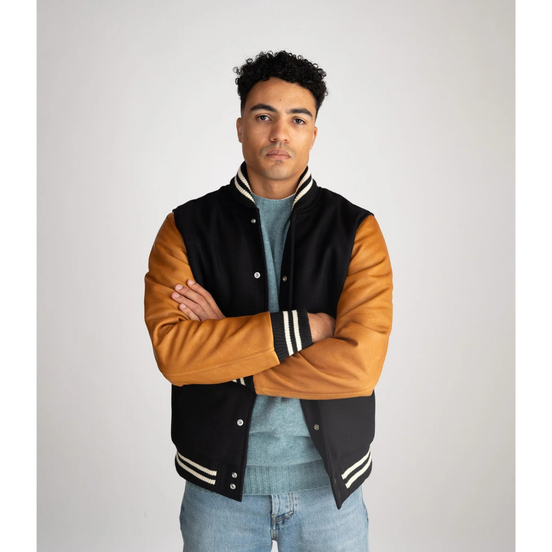 Model wearing Men's Classic Varsity Jacket in Black with Brown Leather Sleeves – displaying a modern yet timeless varsity jacket design.