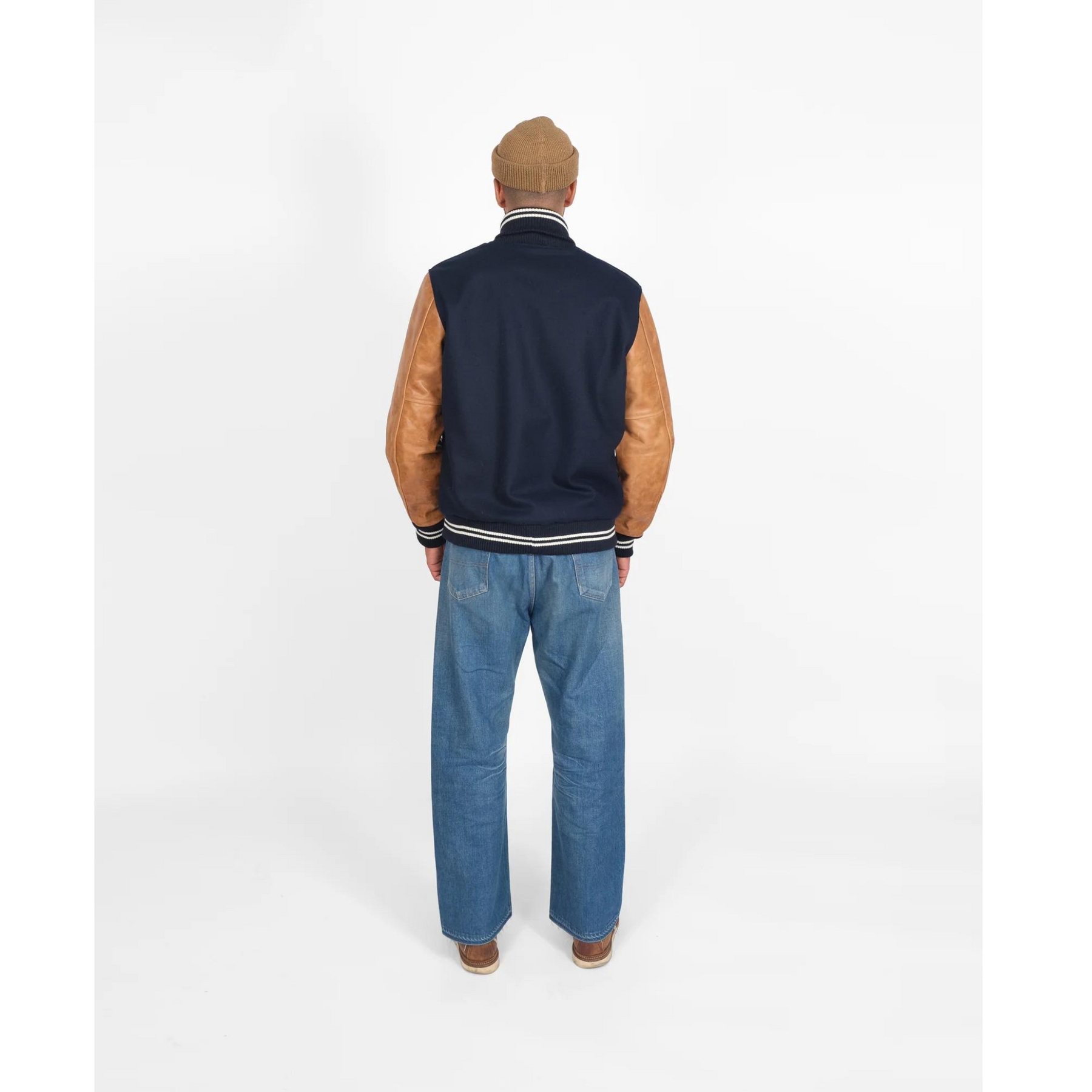 Back view of model in navy varsity jacket