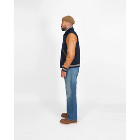 Side profile of model wearing navy varsity jacket