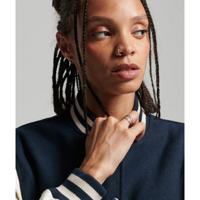 Close-up of model's face wearing navy varsity jacket