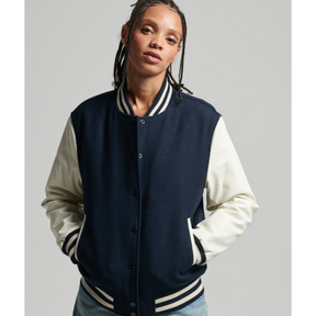 Close-up of model in navy varsity jacket with white sleeves