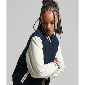 Side angle of model in navy varsity jacket with white sleeves