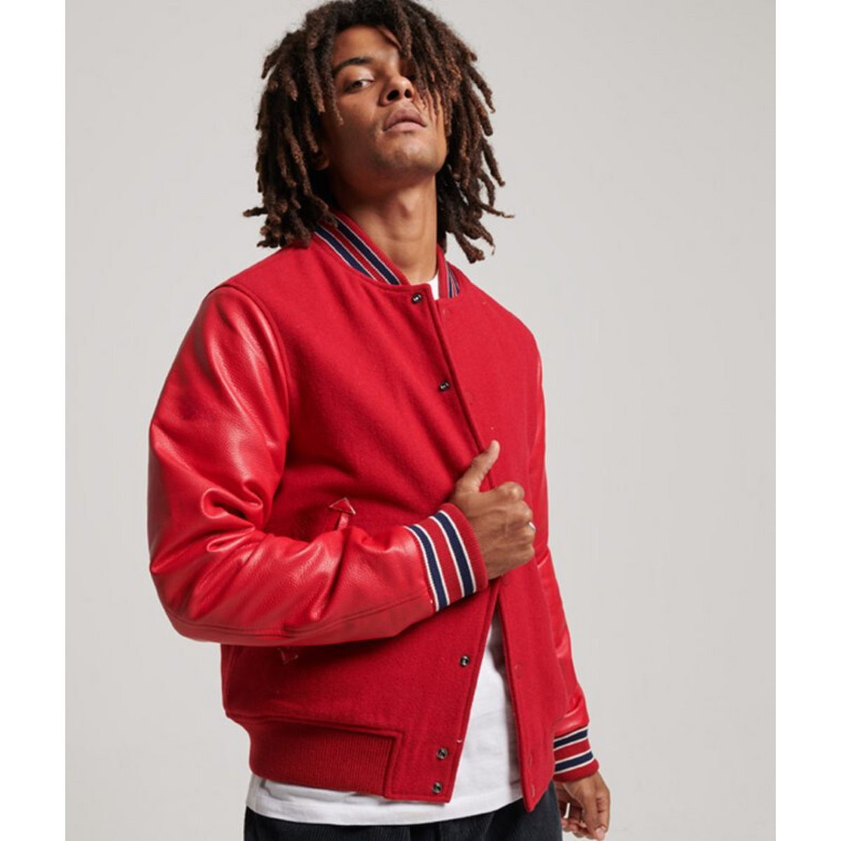 Front full-body shot of a model wearing a red varsity jacket.