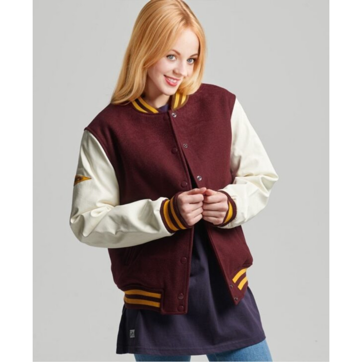 Women's varsity baseball jacket in burgundy with yellow striped cuffs, front view - Alpha Apparel